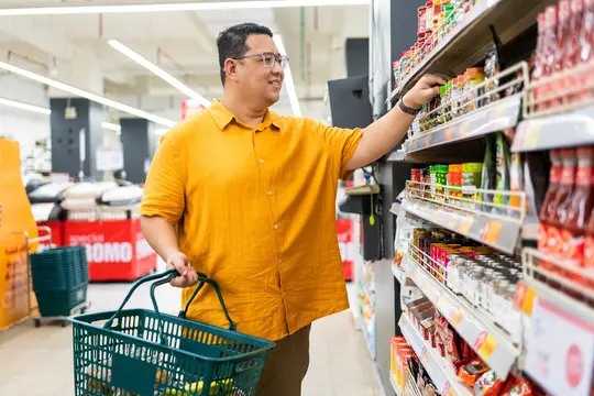 photo of overweight man shopping for food in supermarket