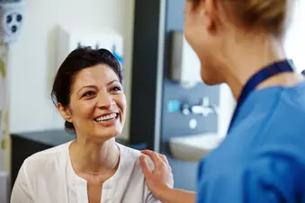 photo of happy mature woman talking with doctor