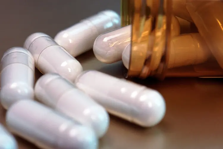 photo of white supplements spilling from bottle
