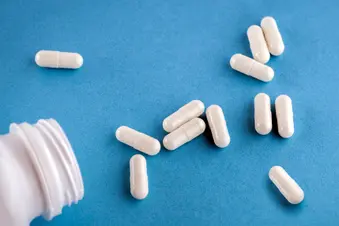 photo of white capsules and pill bottle