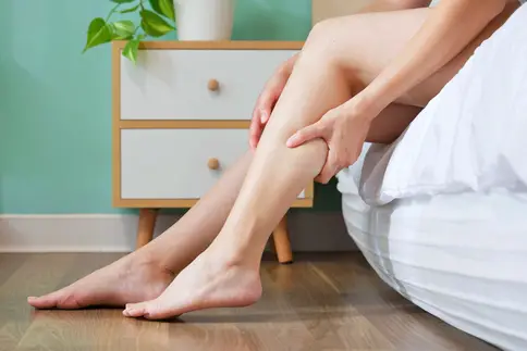 photo of woman massaging sore calf muscle