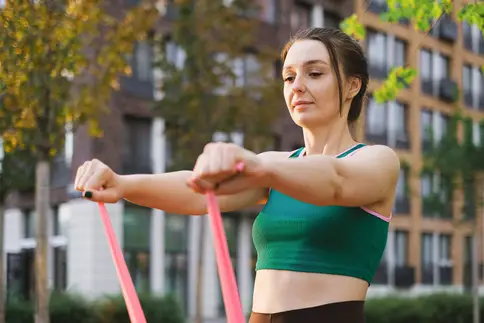 photo of woman using resistance band outdoors