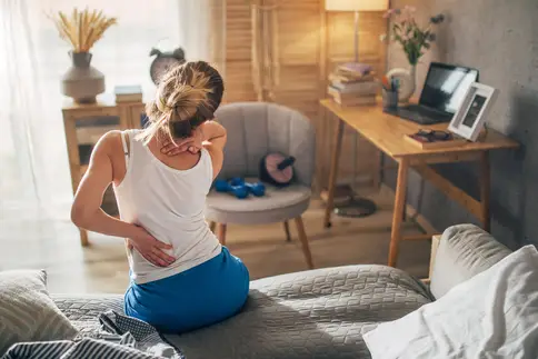 photo of young woman waking up with sore back