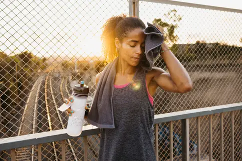 photo of woman wiping sweat