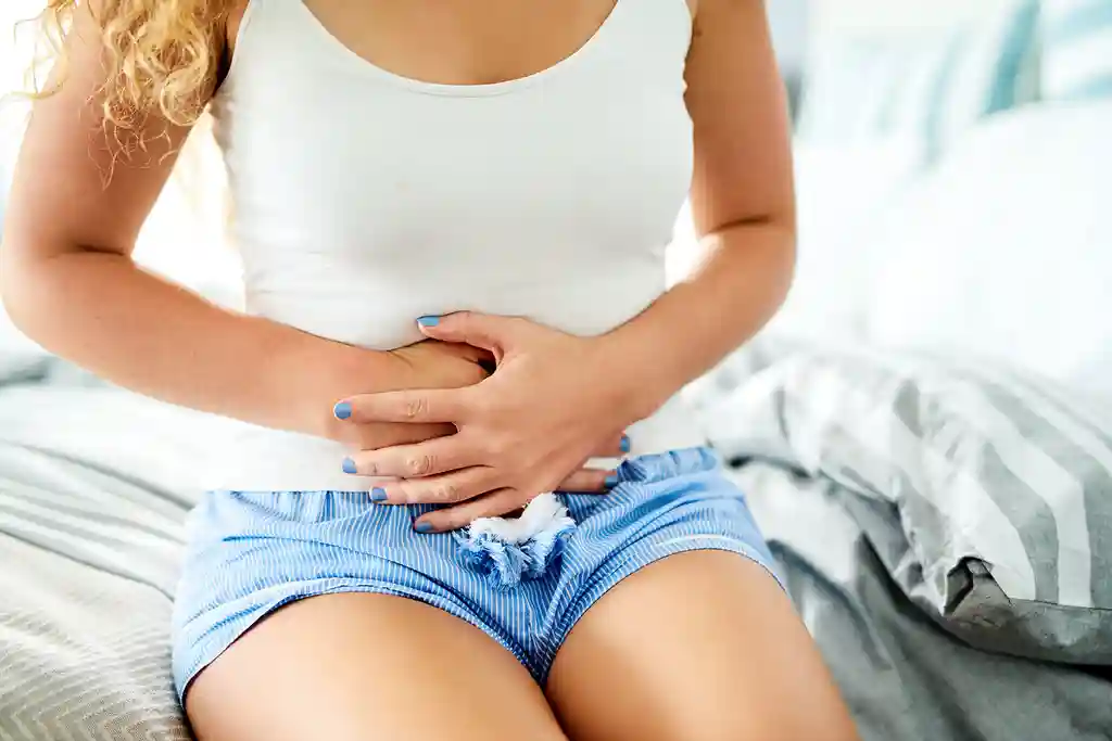 photo of young woman experiencing abdominal pain