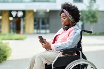 photo of woman in wheelchair using smartphone