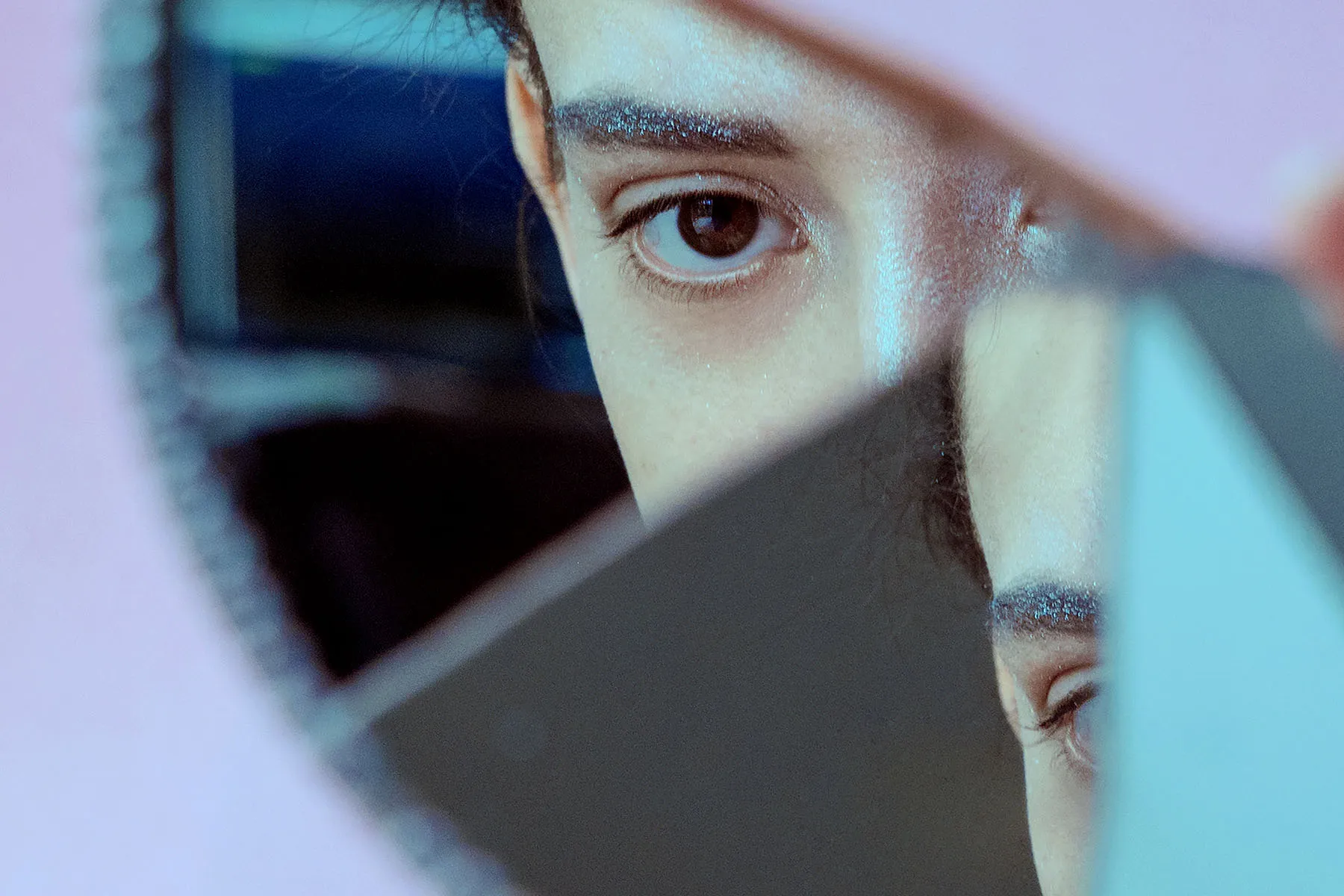 photo of woman looking in fractured mirror