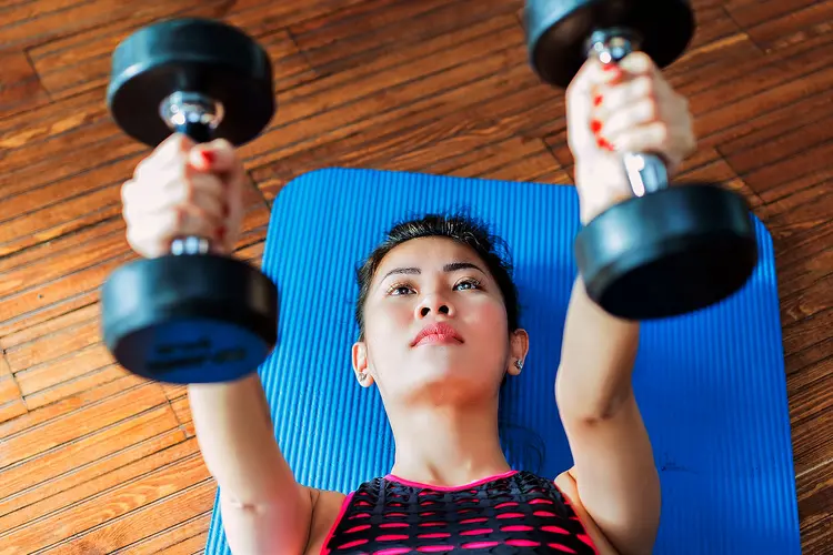 photo of woman lifting hand weights