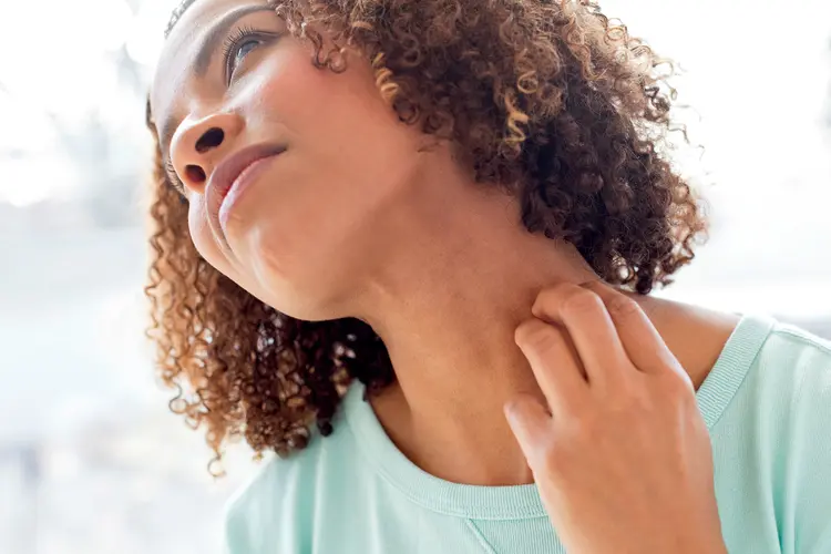 photo of woman scratching her neck