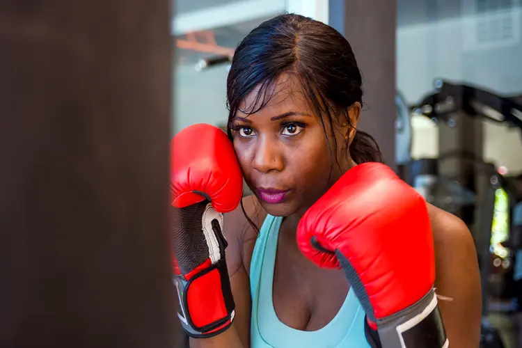 photo of woman working out with punching bag