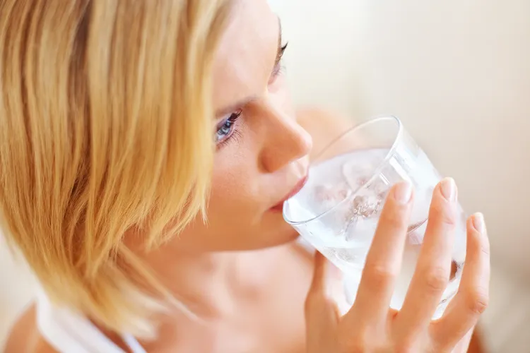 photo of young woman drinking ice water