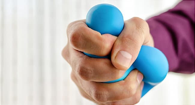 man squeezing stress ball close up