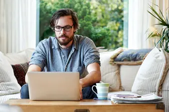 photo of man using laptop at home