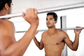 photo of young man holding weightlifting bar