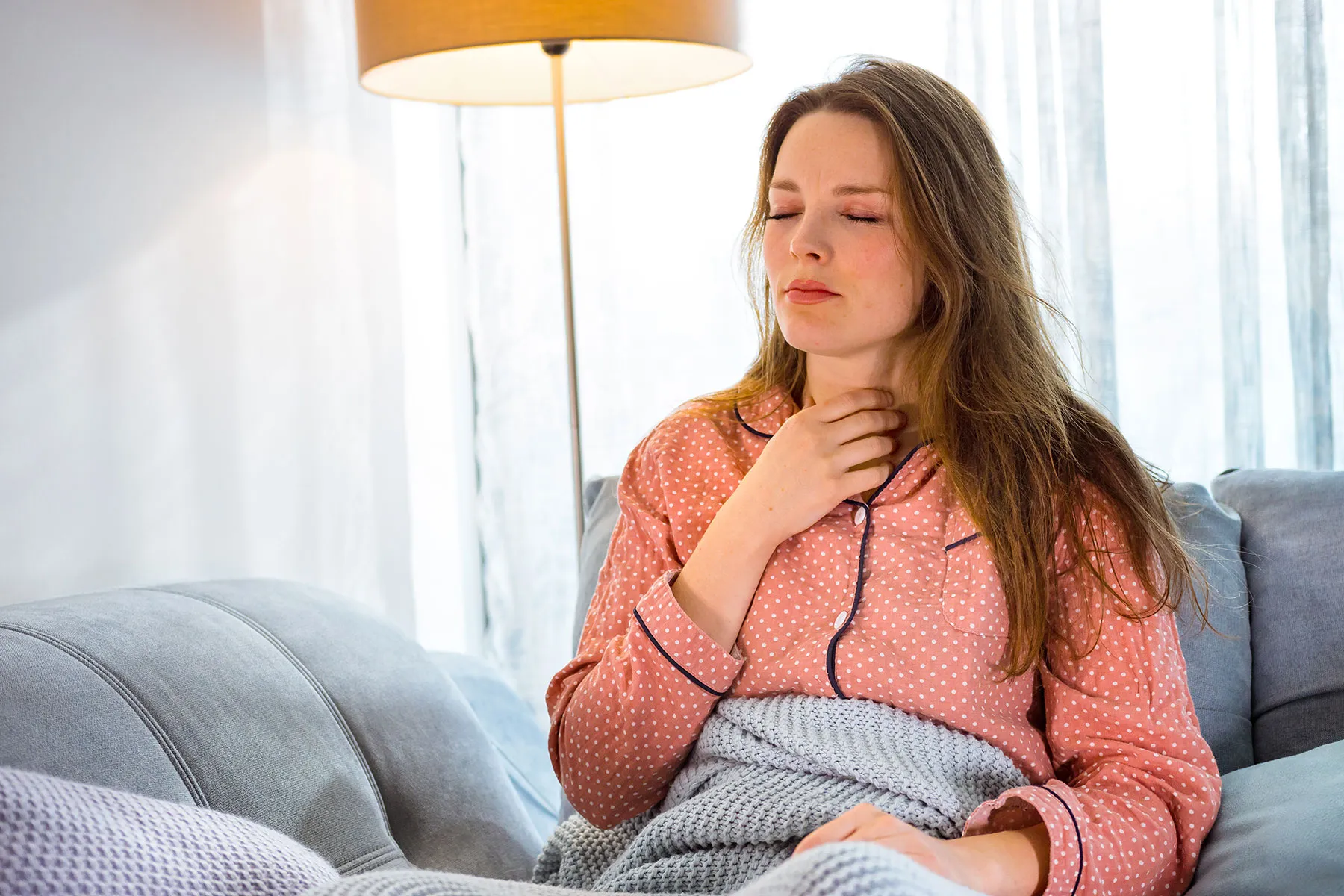 photo of woman holding throat