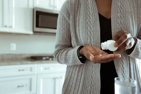 photo of woman taking pills