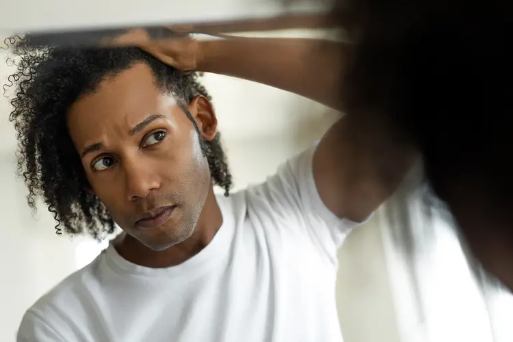 photo of man in front of mirror checking hair