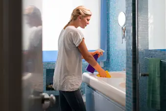 photo of woman cleaning bathroom at home