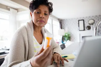 woman reading medication bottle