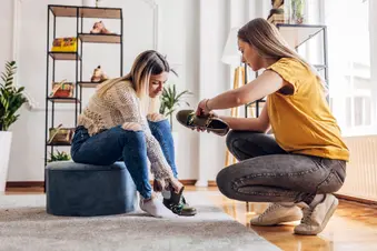 photo of saleswoman helping customer with shoe purchase