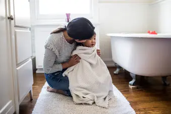 photo of mother drying daughter after bath