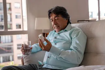 photo of man taking pills at home