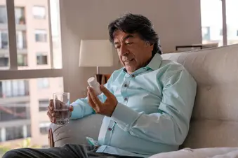 photo of man taking pills at home