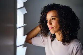 photo of young woman looking out window