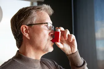 man using asthma inhaler