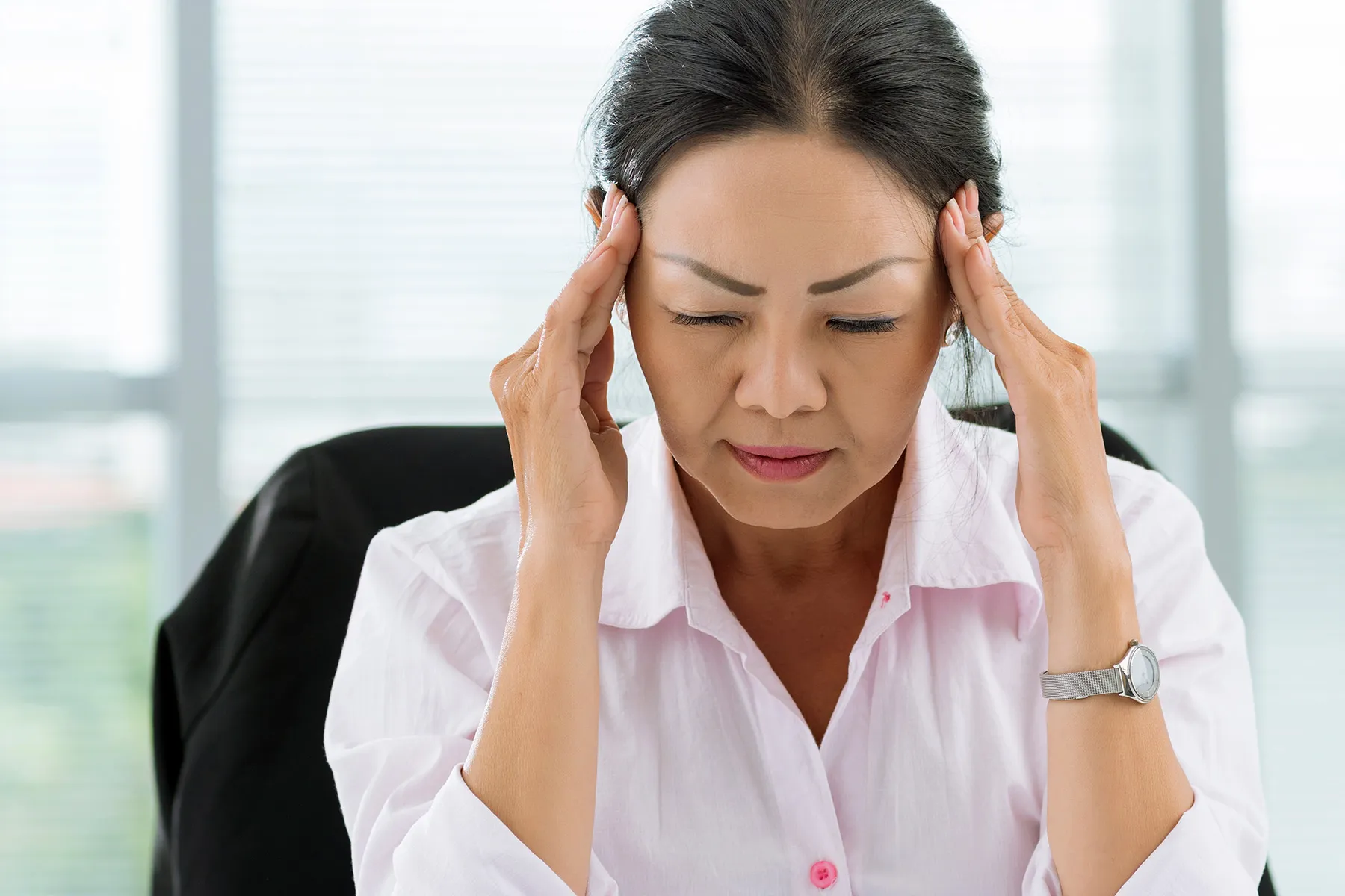 photo of mature woman in office with headache