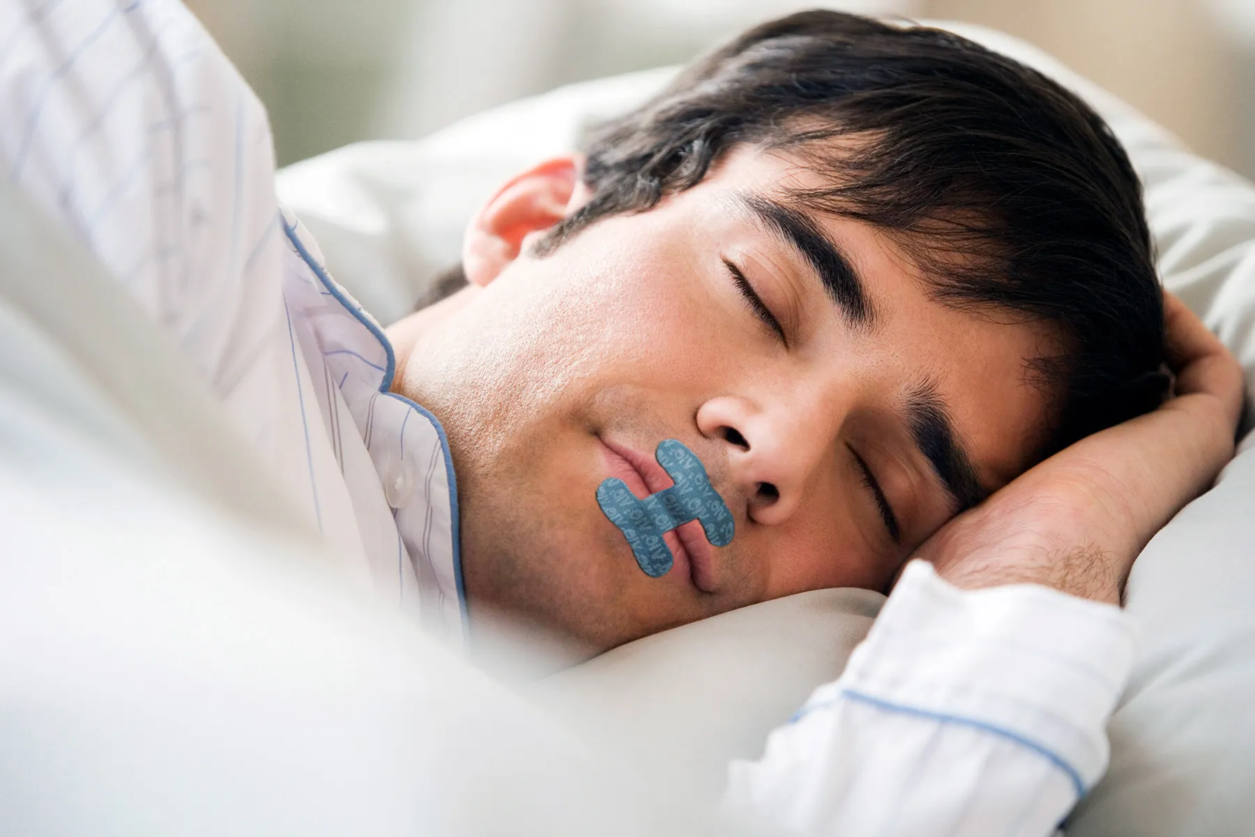 photo of man asleep in bed with mouth taped