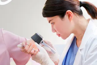 photo of dermatologist examining patient's hand