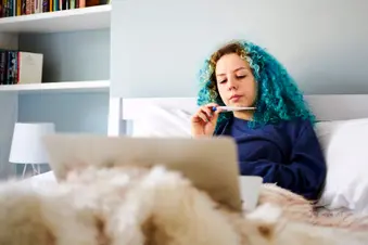 photo of teenage girl checking temperature in bed