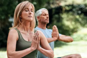 photo of mature couple meditating outdoors