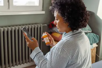photo of mature woman reading prescription pill bottle label
