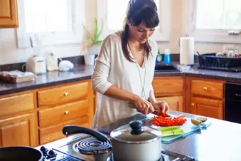 photo of woman cutting vegetables in kitchen