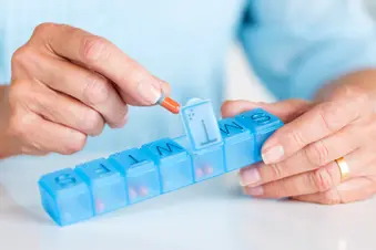 photo of taking pill from weekly organizer
