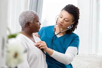 photo of doctor checking mature woman's heart