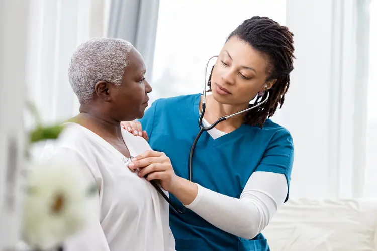 photo of doctor checking mature woman's heart