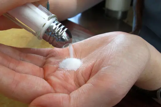 photo of pouring salt into palm of hand