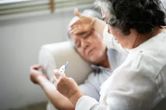 photo of senior wife checks husband's temperature