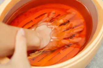 hand soaking in paraffin bath