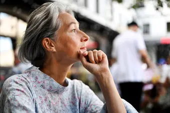 photo of thoughtful mature woman sitting in cafe