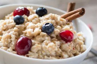 photo of bowl of oatmeal, berries and cinnamon