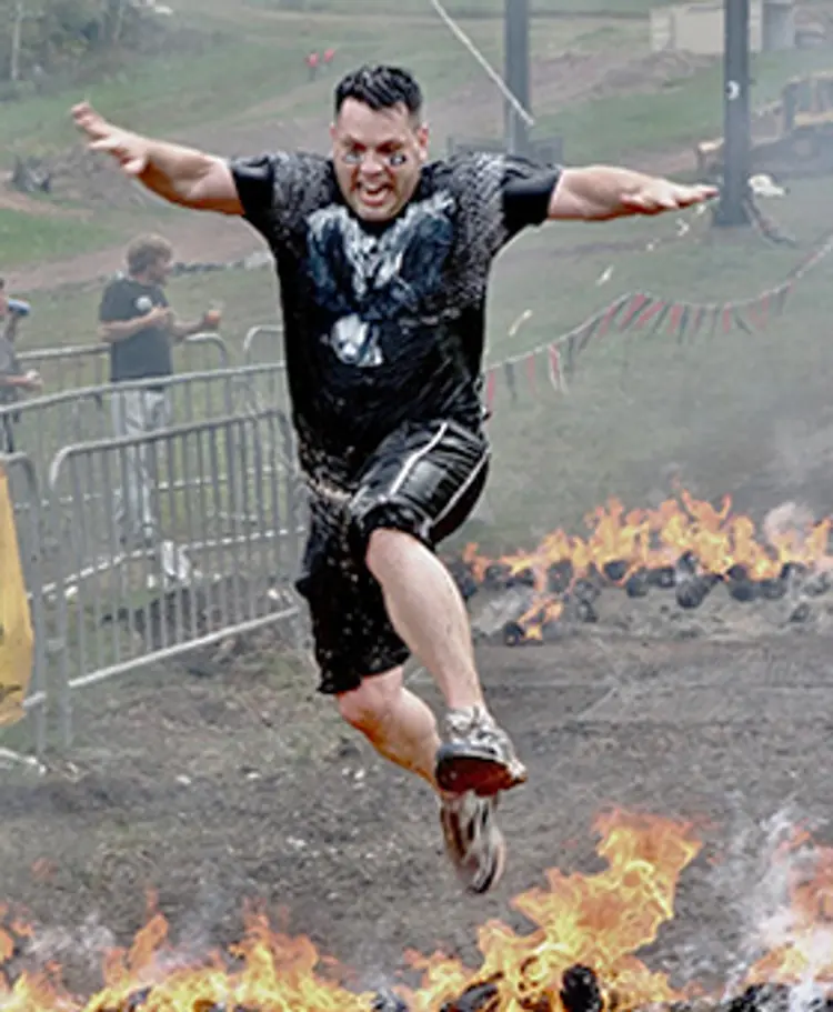 photo of man jumping over fire