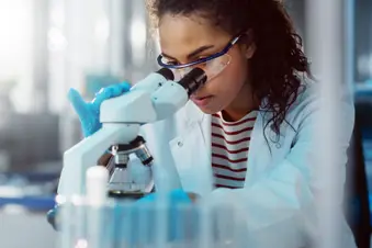 photo of medical researcher using microscope