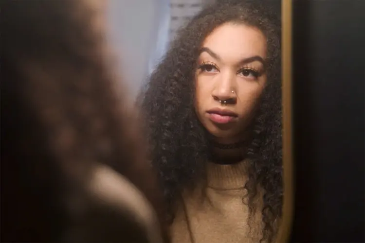 photo of woman looking in mirror