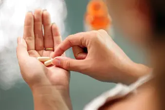 photo of woman taking pill