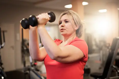 photo of woman lifting weights