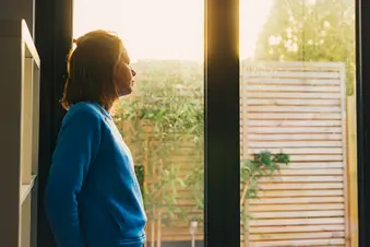 photo of mature woman looking out window